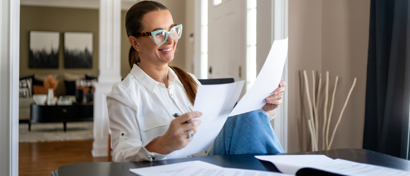 relaxed woman in glasses looking at paperwork